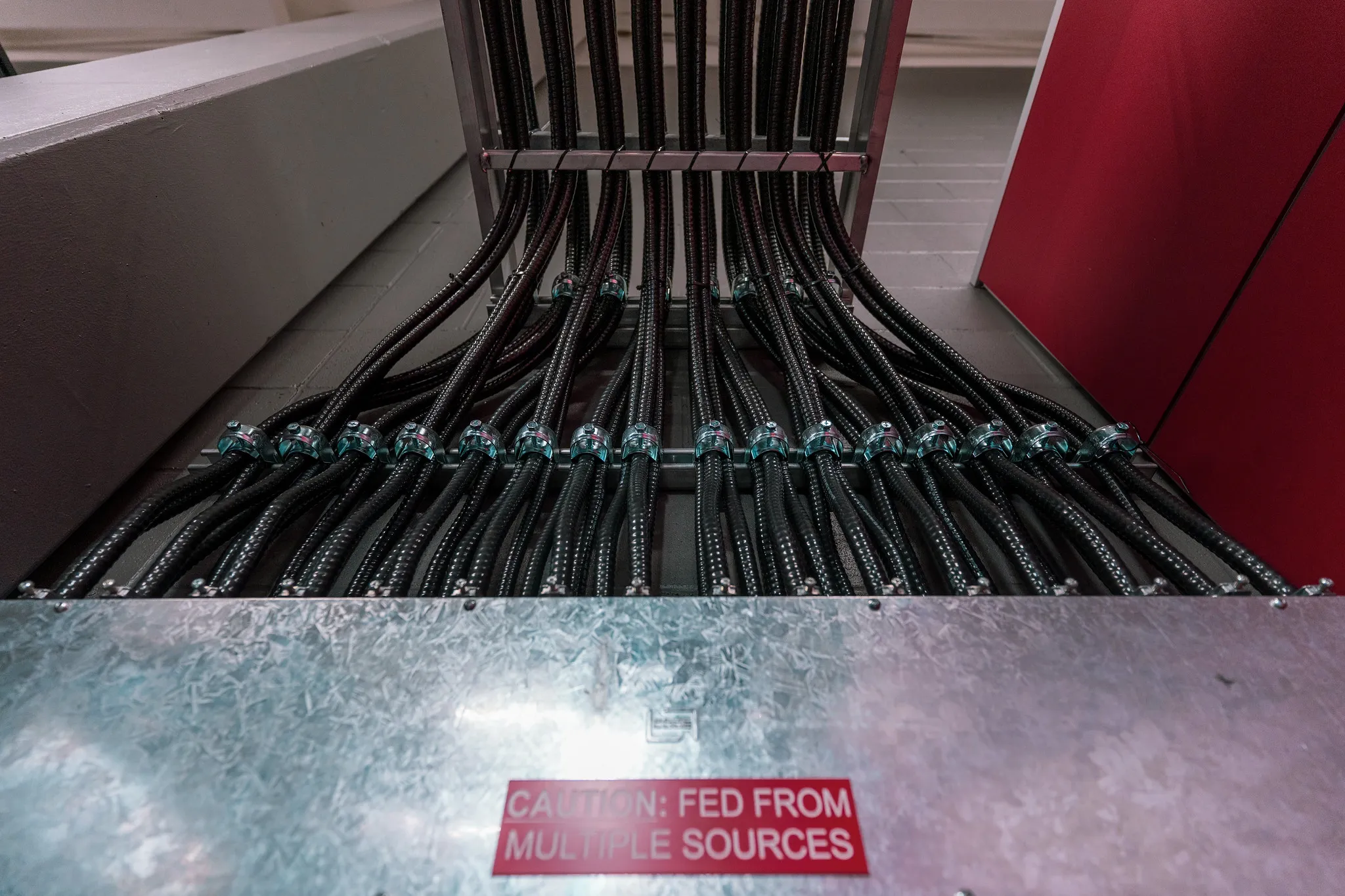 Commercial electrical conduit runs entering a panel box